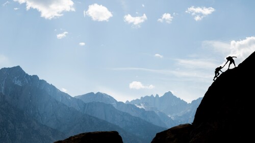 Rock-climbers-assisting-each-other-on-their-way-to-summit.jpg